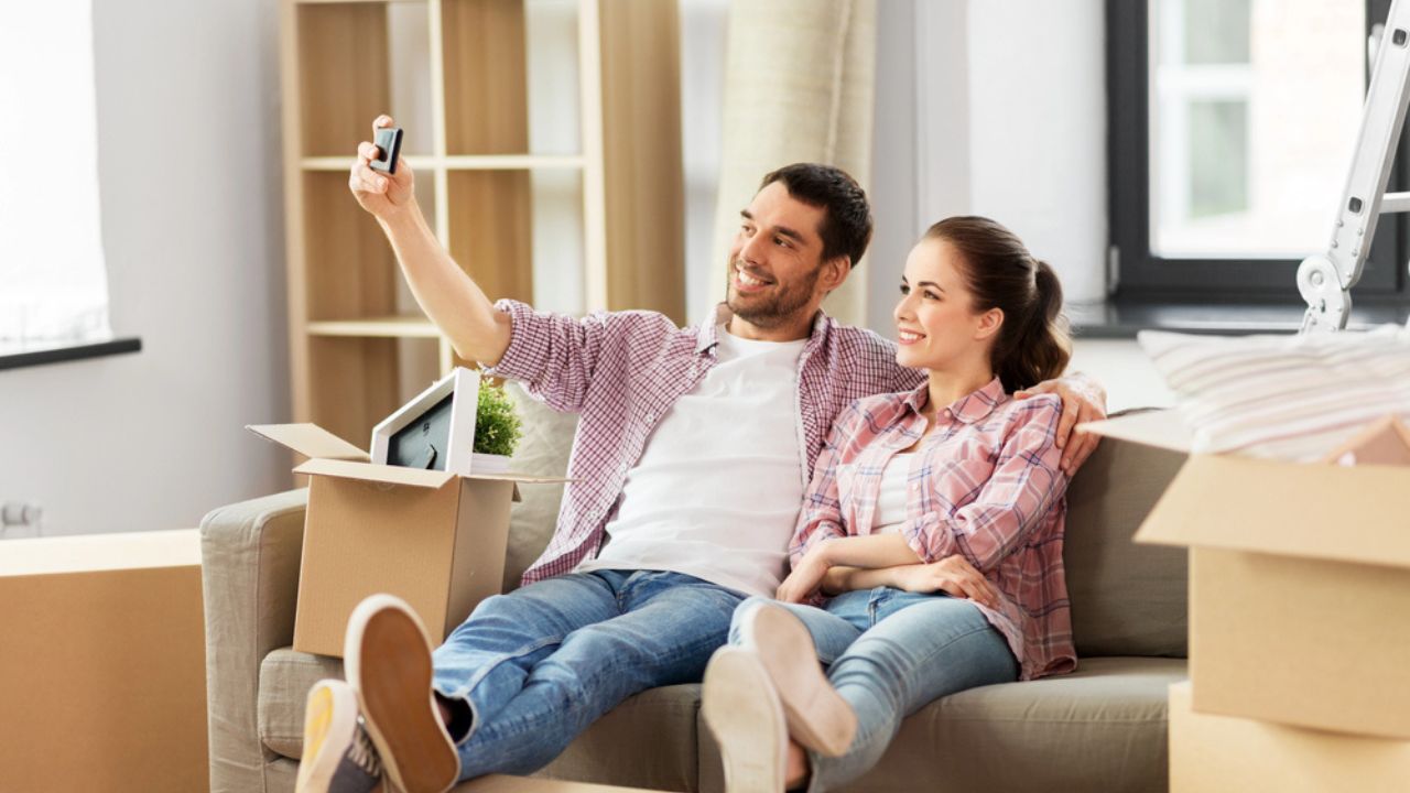 Couple taking selfie by smartphone at new home