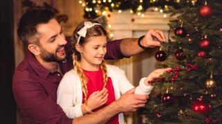 Father and daughter decorating christmas tree