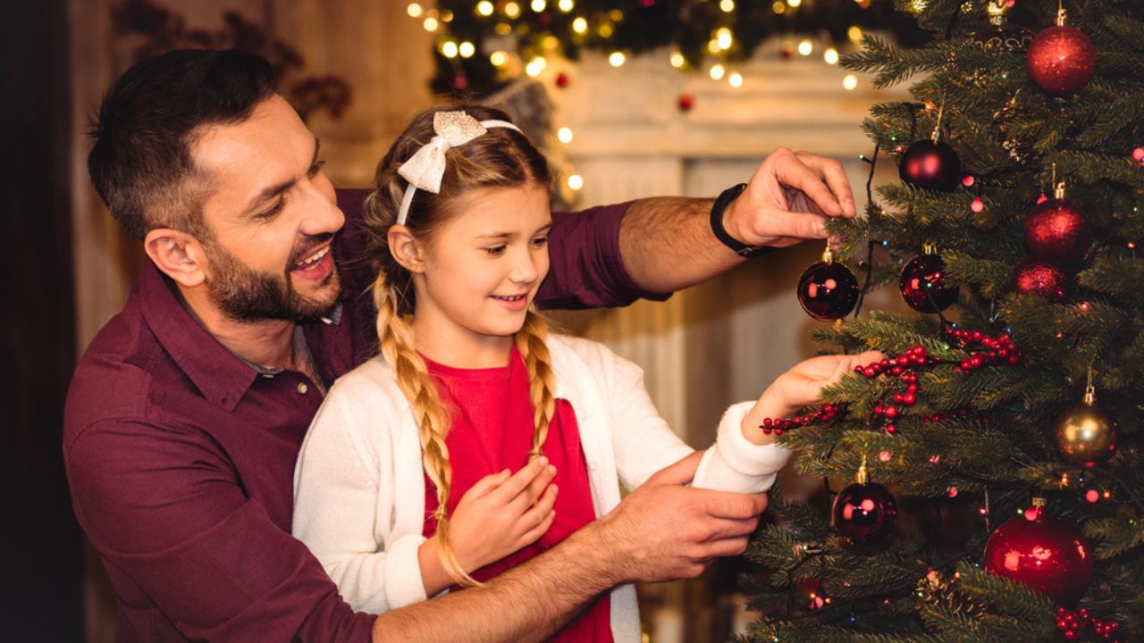 Father and daughter decorating christmas tree