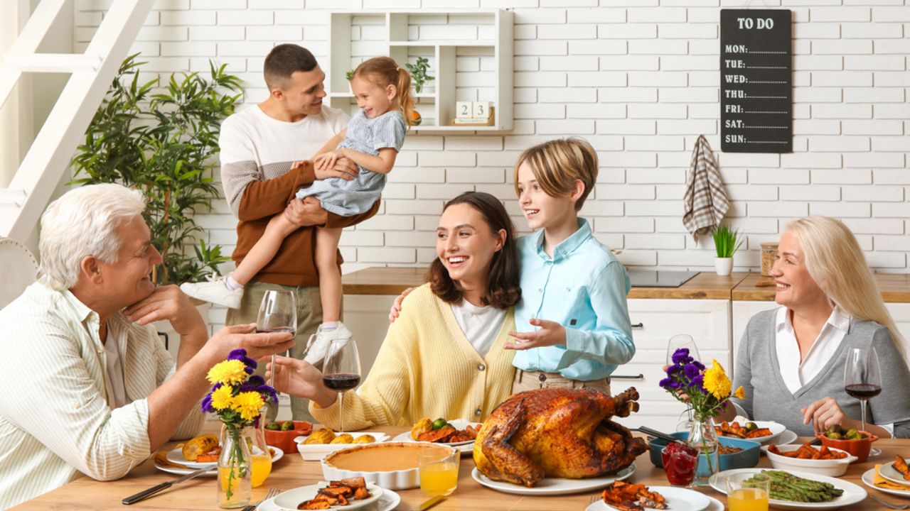 Happy family having dinner at festive table on Thanksgiving Day