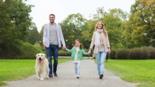Happy family with labrador retriever dog in park