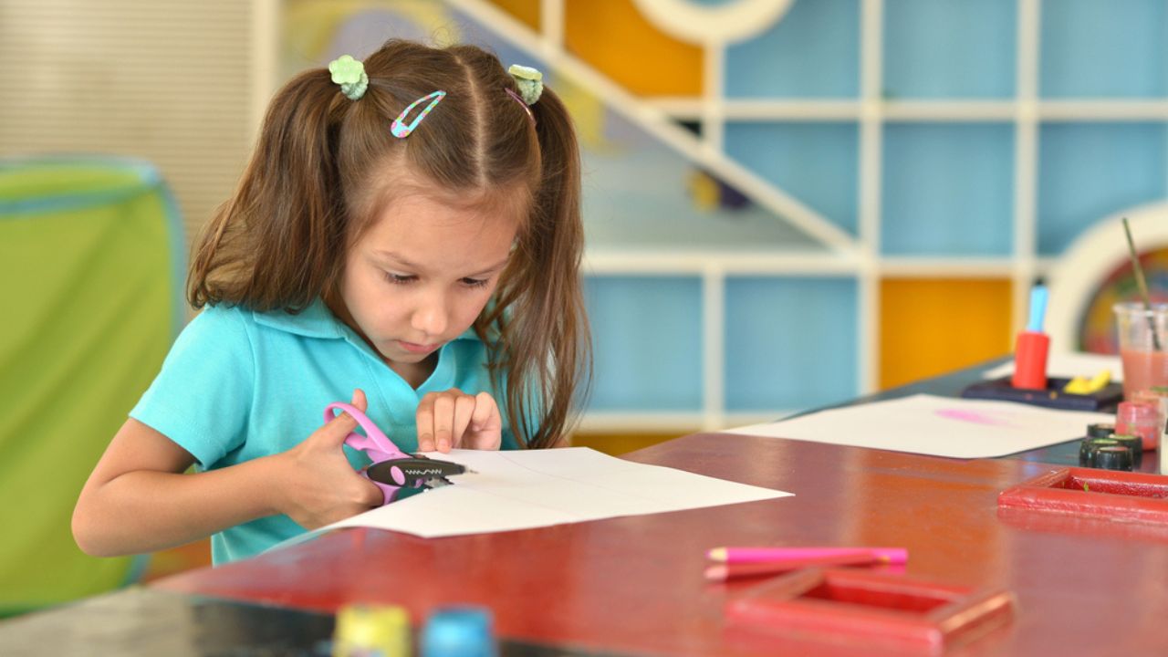 Little girl cutting paper