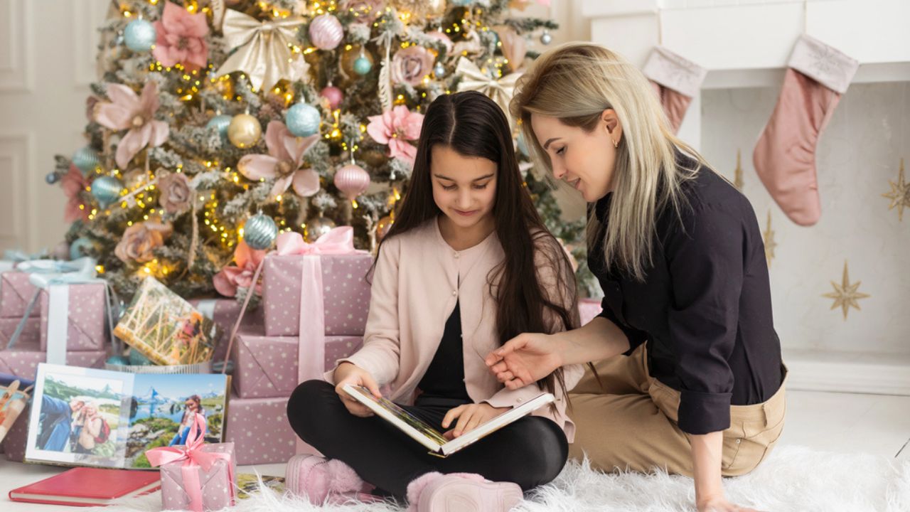 Mother and daughter at home on the couch leafing through and looking a book with photos