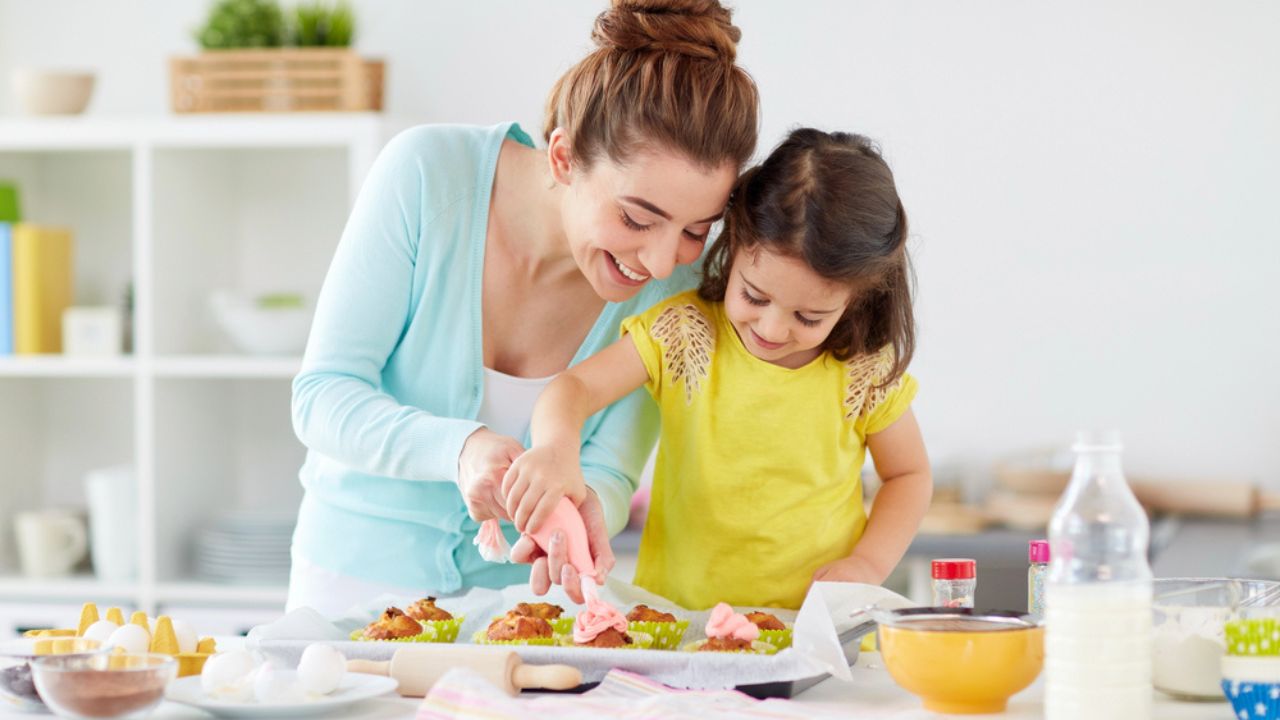 Mother and daughter cooking cupcakes at home