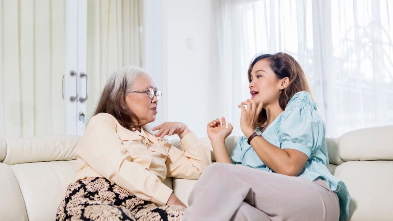 Old woman speaking with her daughter at home