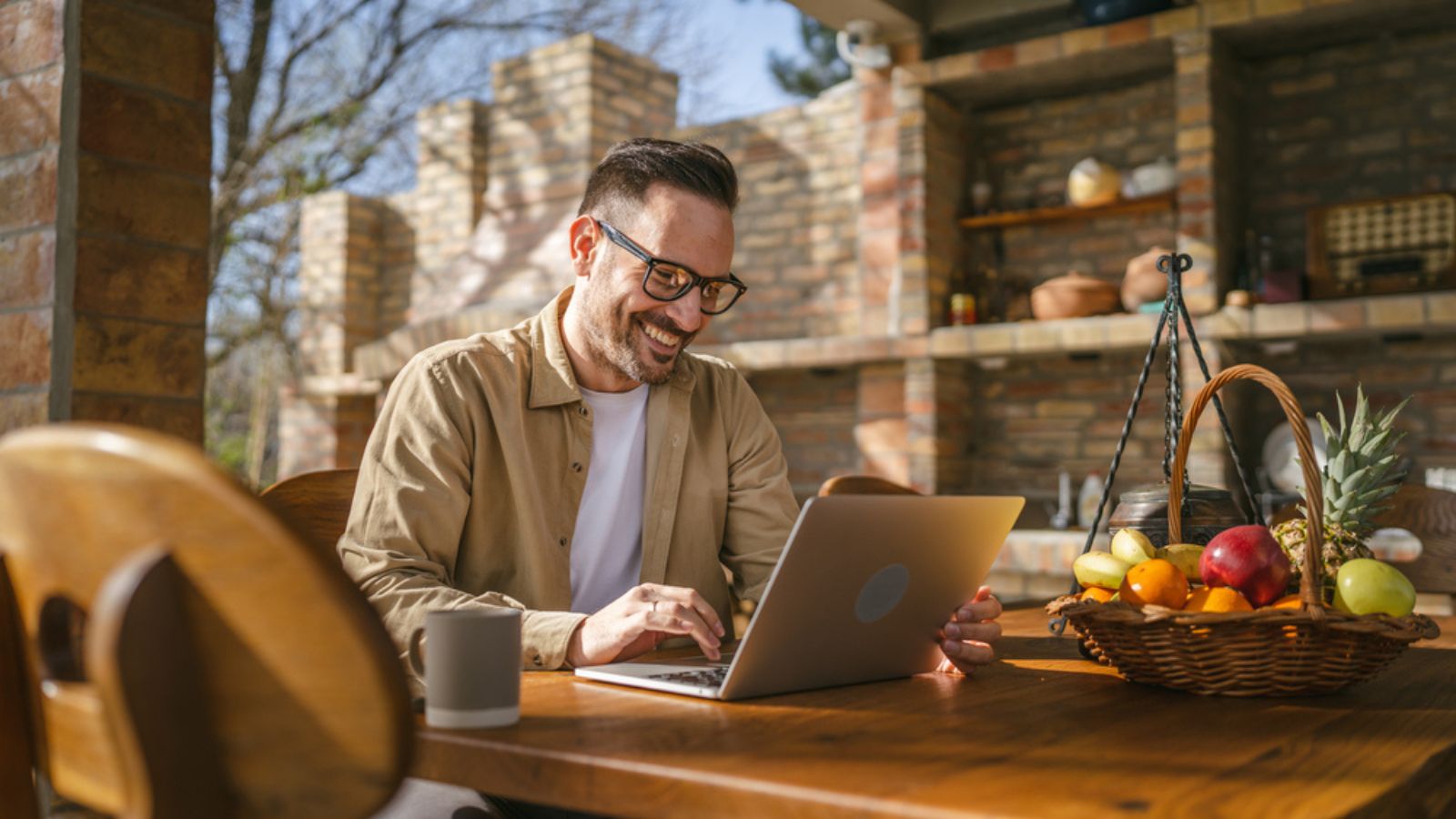 One man caucasian modern male sit on the balcony terrace alone at home wear shirt work on laptop computer in day remote happy smile confident success concept copy space