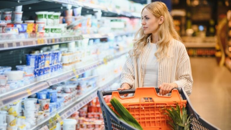 Portrait Of Smiling Woman With Shopping Cart In Supermarket Buying Groceries Food