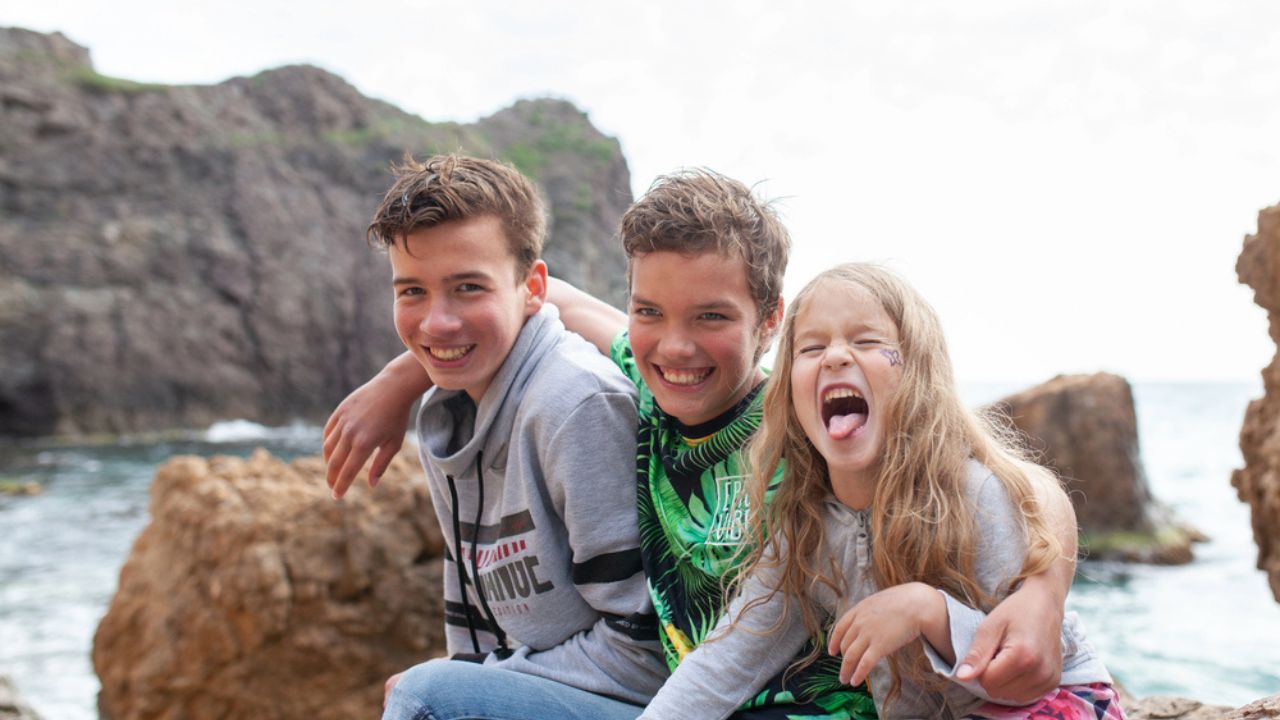 Portrait of happy brothers and sisters on the background of the sea