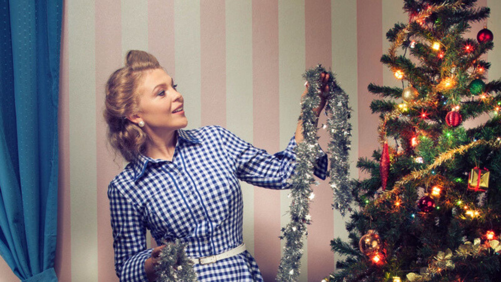 Portrait of nice young woman hanging around christmas tree on x-mas eve