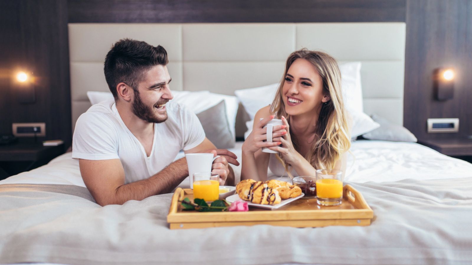 Romantic happy couple having breakfast in bed
