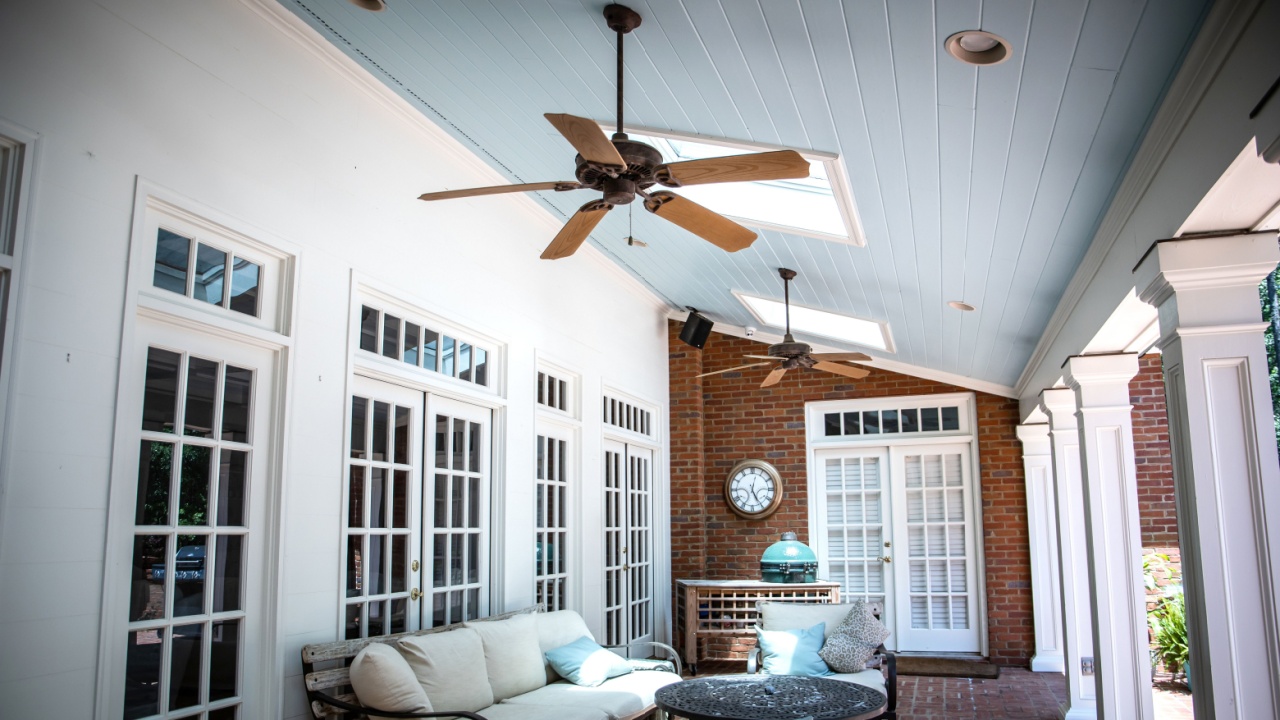 Outdoor Residential Back Patio Porch with Couches and Chairsand a Table with a copper ceiling an