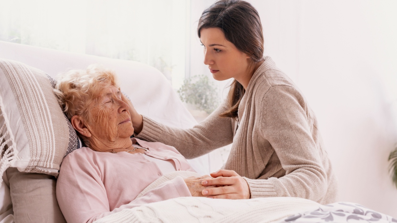 Young daughter supporting sick mother lying in hospital bed