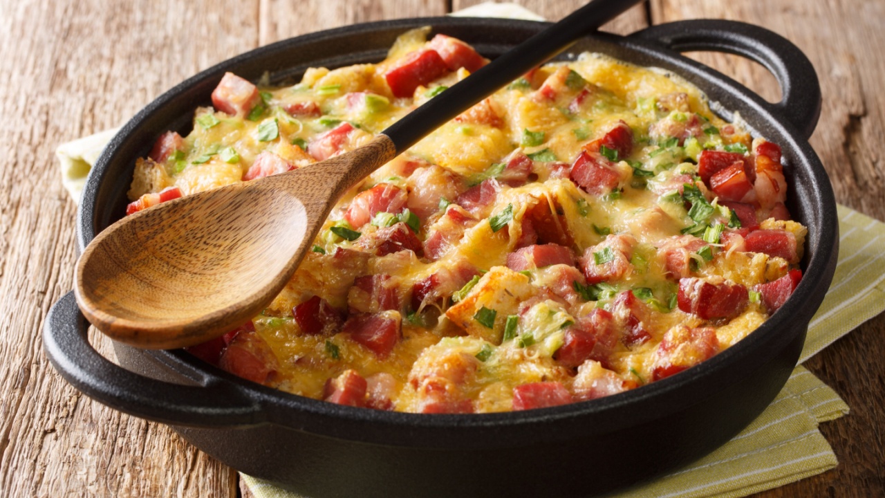 Tasty hot homemade strata with ham, onions, cheese and eggs close-up in a pan on the table. horizontal