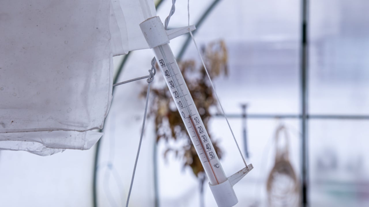 Mercury thermometer in a greenhouse, outside the house shows cold weather below zero