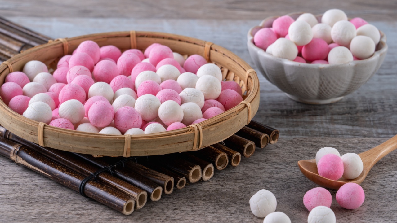 Raw red and white tangyuan glutinous rice dumpling balls on wooden table background for Winter solstice festival food.