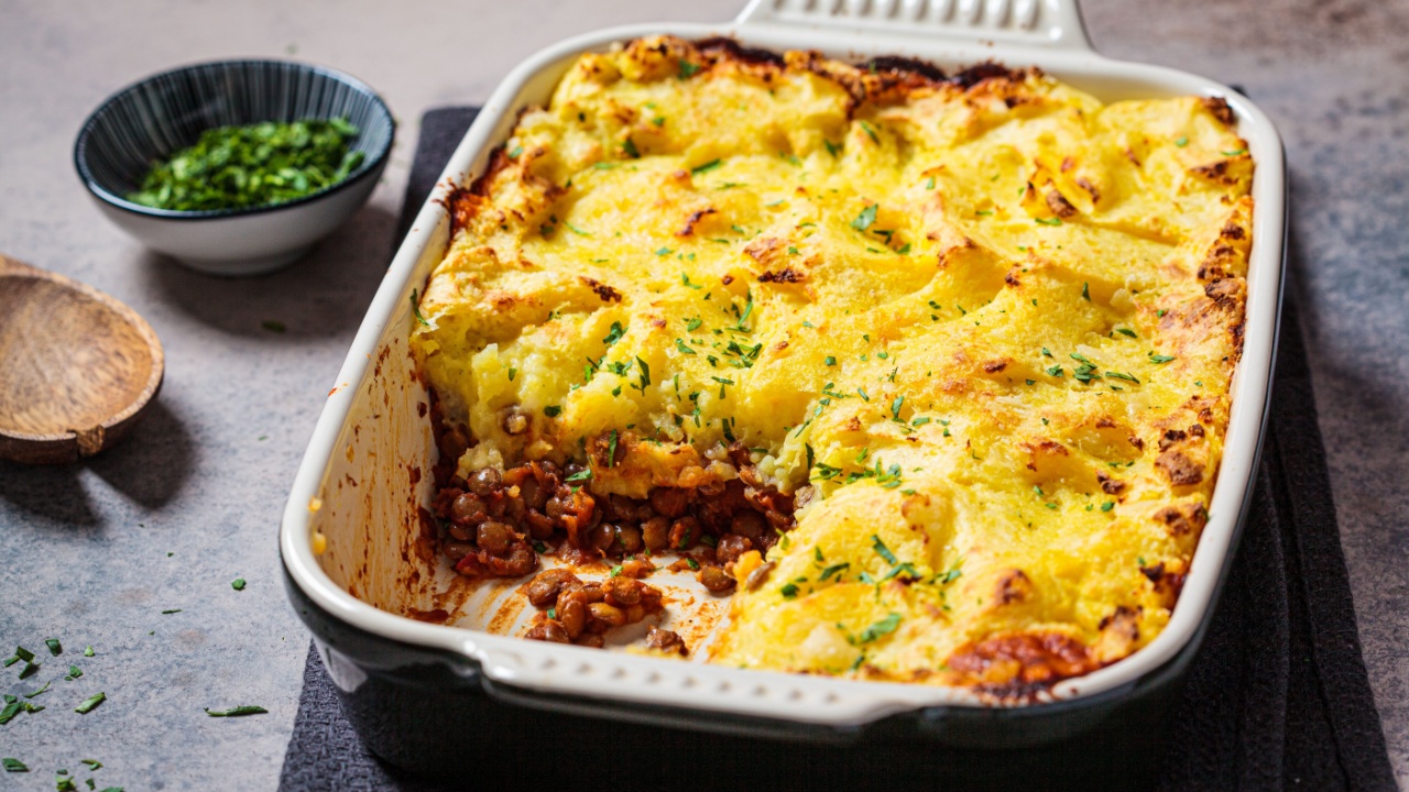 Vegan shepherd's pie with lentils and mashed potatoes in black backing dish. Vegan food concept.