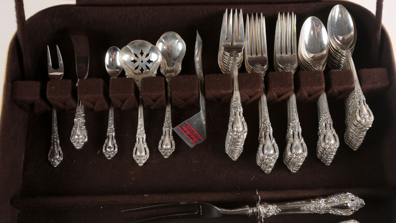 A collection of antique silver flatware. The cutlery may include Spoons, Forks and knives. Photographed on a white background.