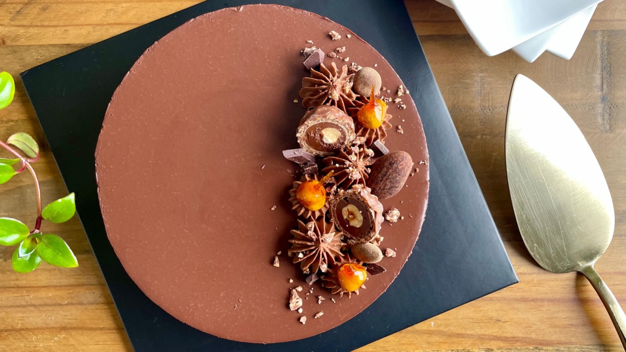 Chocolate cheesecake topped with ganache and decorated with chocolates and candied hazelnuts