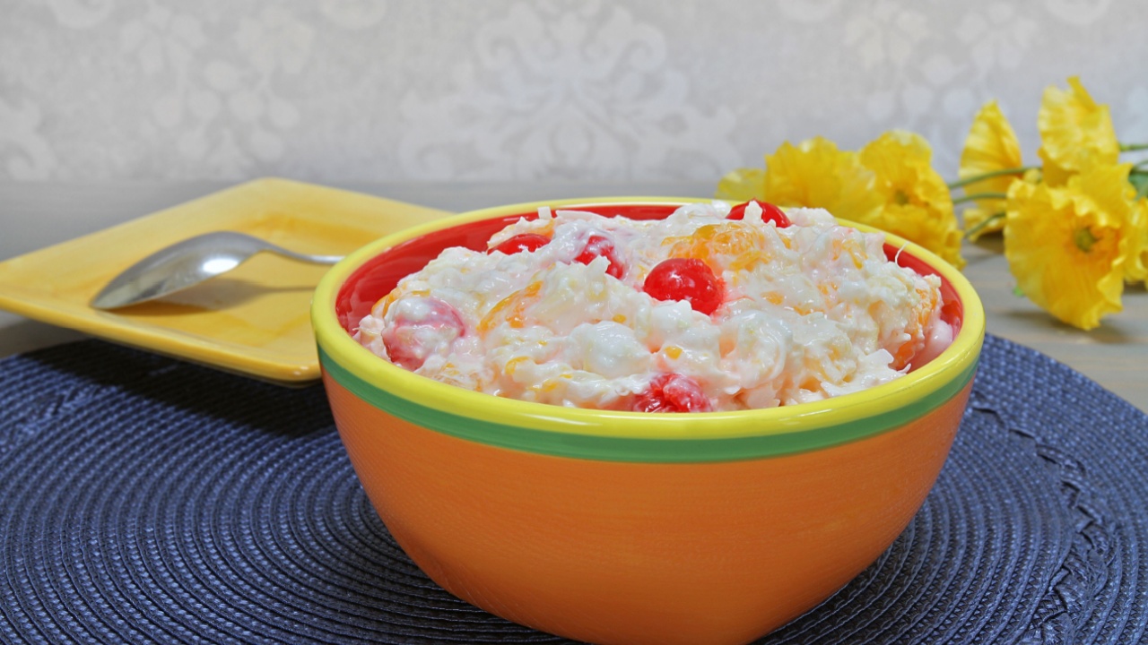A colorful bowl of fruit and marshmallo salad also known as ambrosia salad.
