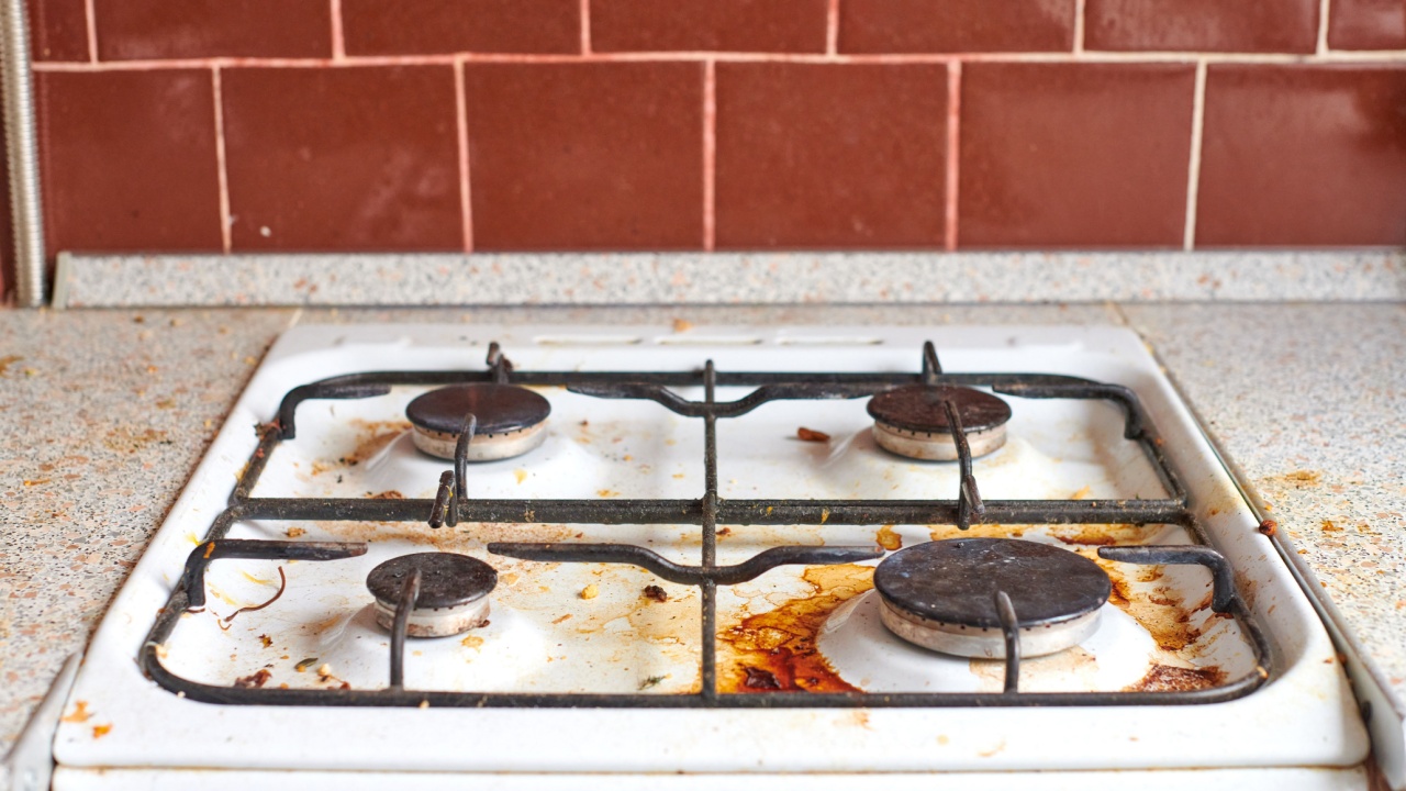Dirty stove with food leftovers. Unclean gas kitchen cooktop with greasy spots, old fat stains, fry spots and oil splatters.
