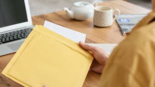 Young man with letter at home, closeup