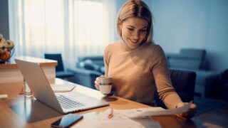 Woman working from home managing domestic bills and invoices, calculating expenses and paying taxes