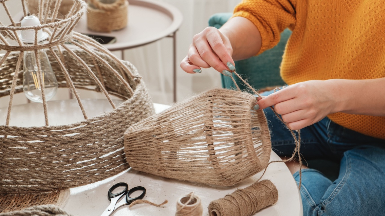 Close up Woman makes handmade diy lamp from jute rope