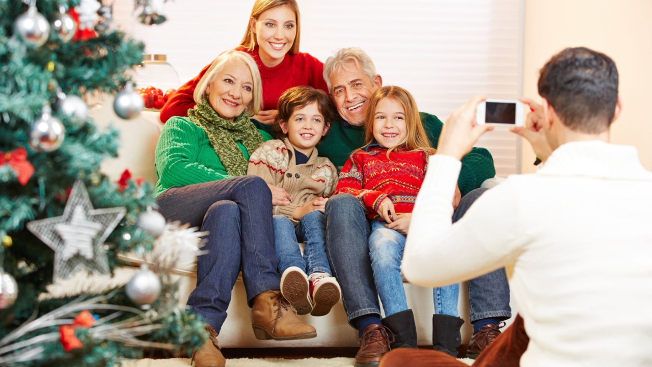 Father taking family picture at christmas with his smartphone