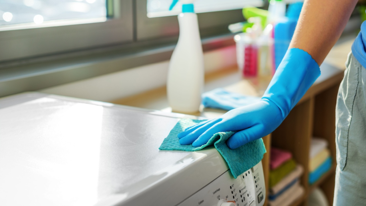 Woman holding a detergent and cleaning the washing machine, appliance hygiene concept