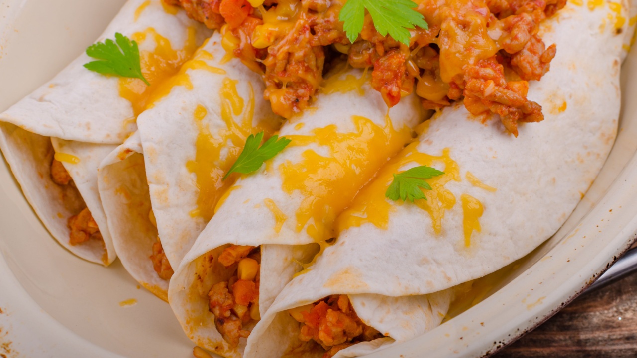 Baked meat tortilla with cheddar cheese, chilli peppers and corn, lime drink