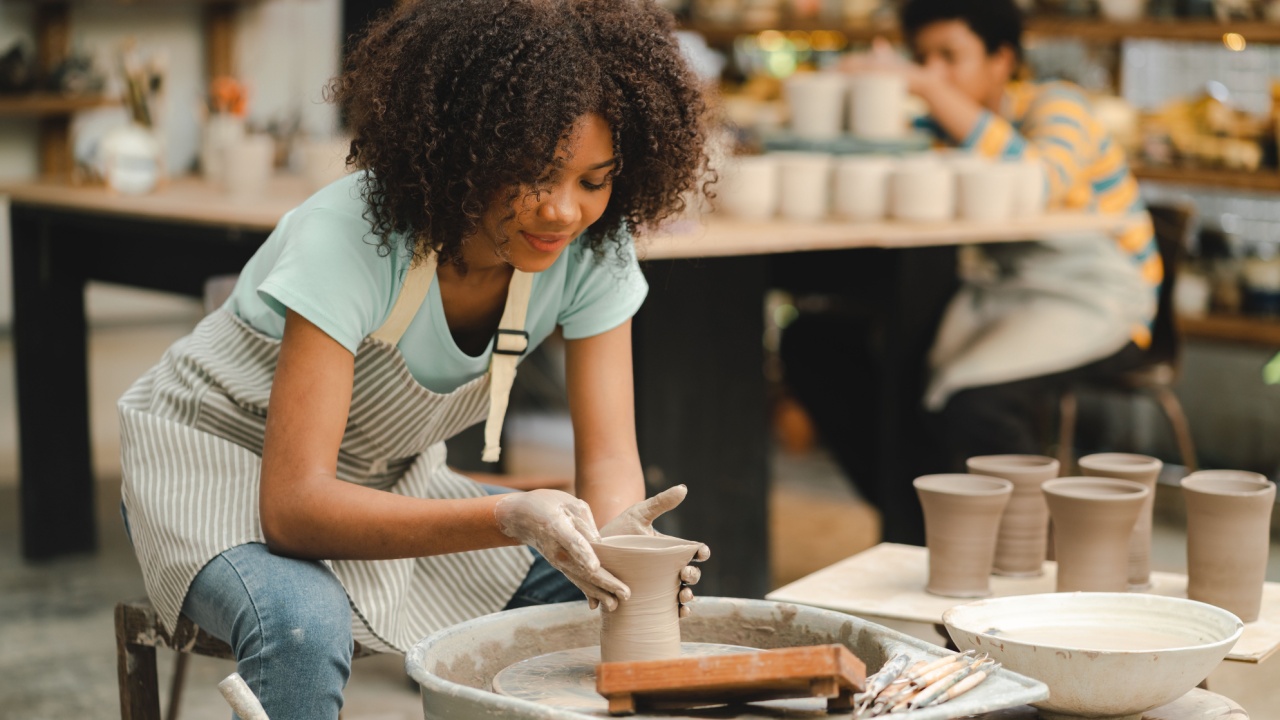 happy smiling girl having fun to learning and work with craft art of clay hand-made workshop in ceramic studio, little ceramist enjoy in creative handcraft hobby with pottery artisan school class