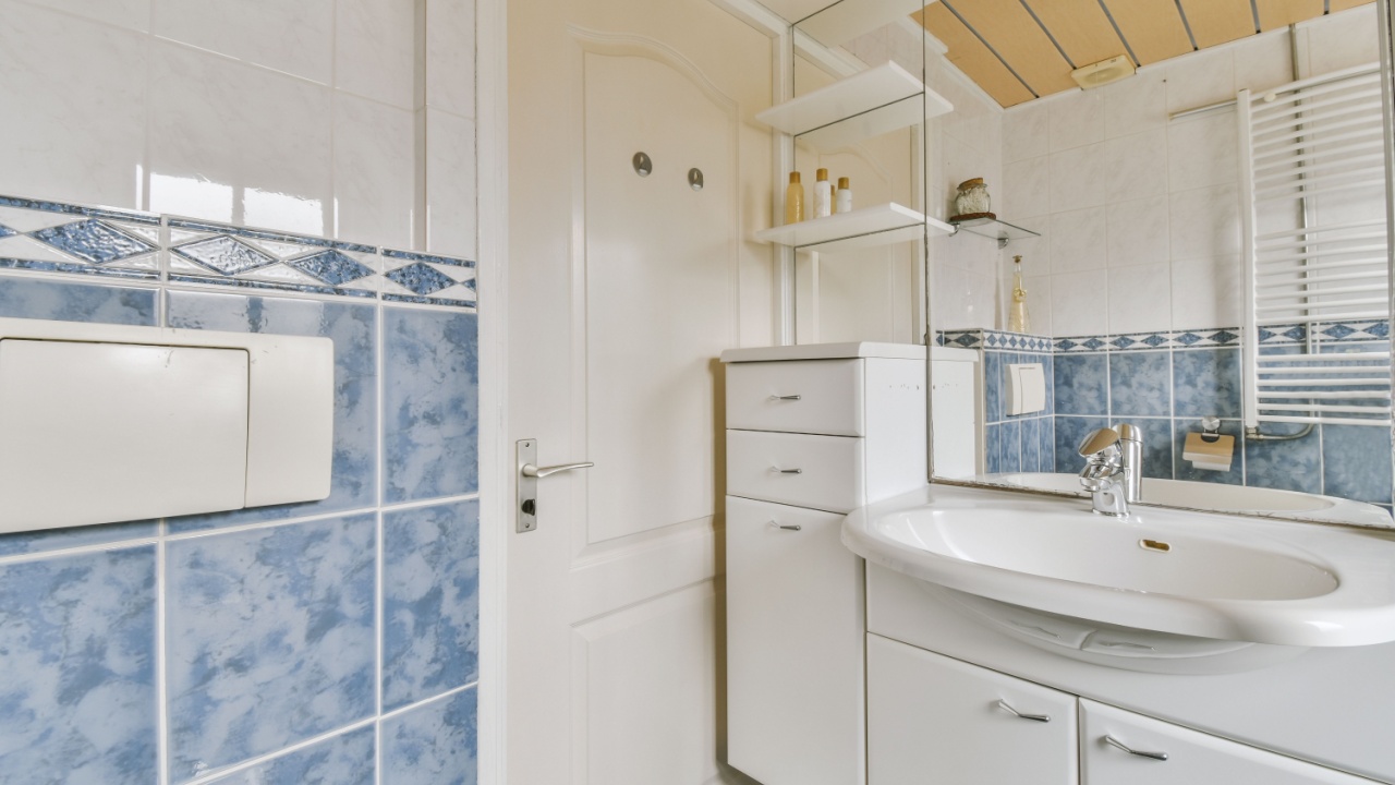 Sinks with mirrors and clean bathtub located near shower box with glass door in modern bathroom with white tiled walls