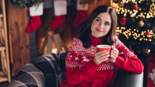Photo of adorable positive lady sit chair hands hold hot coffee cup think imagine house indoors