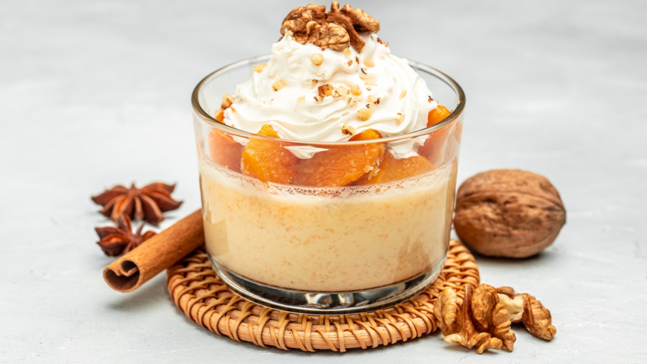 dessert with pumpkin, whipped cream. Pumpkin parfait with nuts in glass on a light background. banner, menu, recipe place for text, top view.