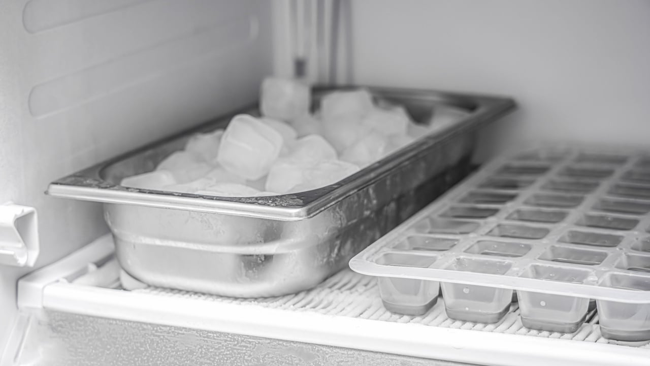 Frozen ice cubes in a stainless steel bowl in the freezer