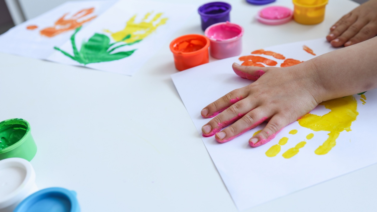 Children's art workshop, the child makes a handprint with paints.