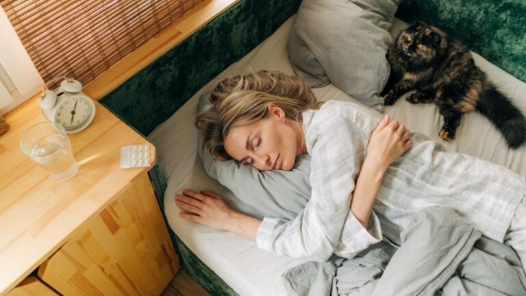 Carefree woman sleeping in bed early in the morning.