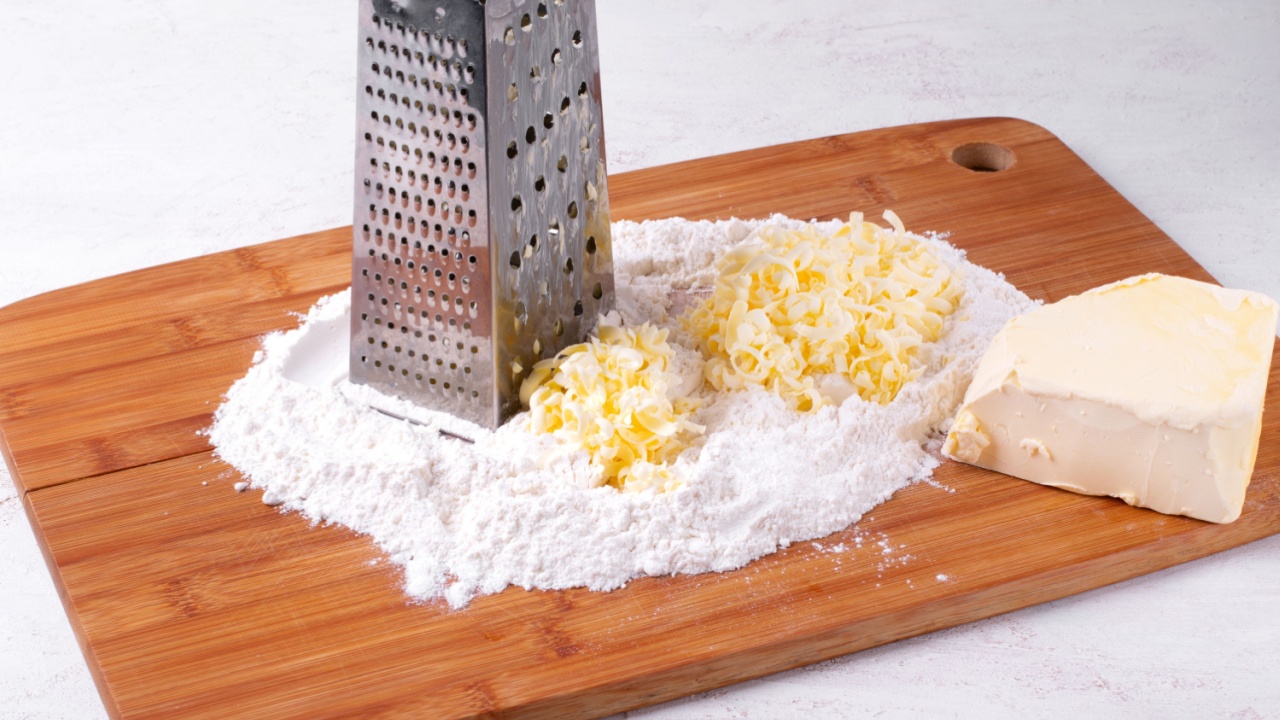 Grating frozen butter into wheat flour on wooden board. Making chopped dough or quick puff pastry. Baking ingredients. Step by step recipe