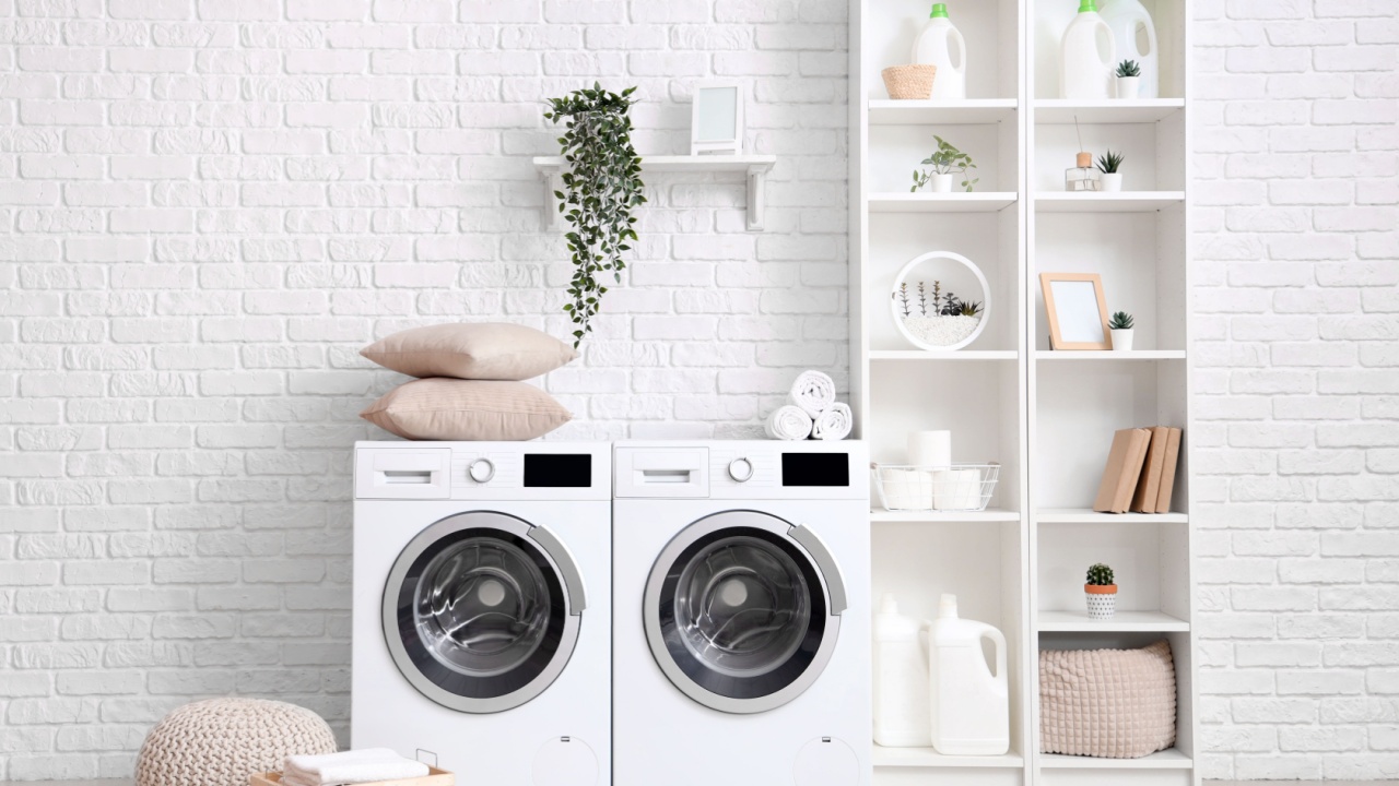Interior of laundry room with washing machines and shelving unit