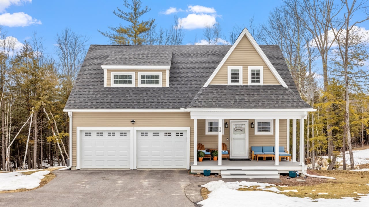 A cozy house in a rural setting with a blanket of snow covering the ground.
