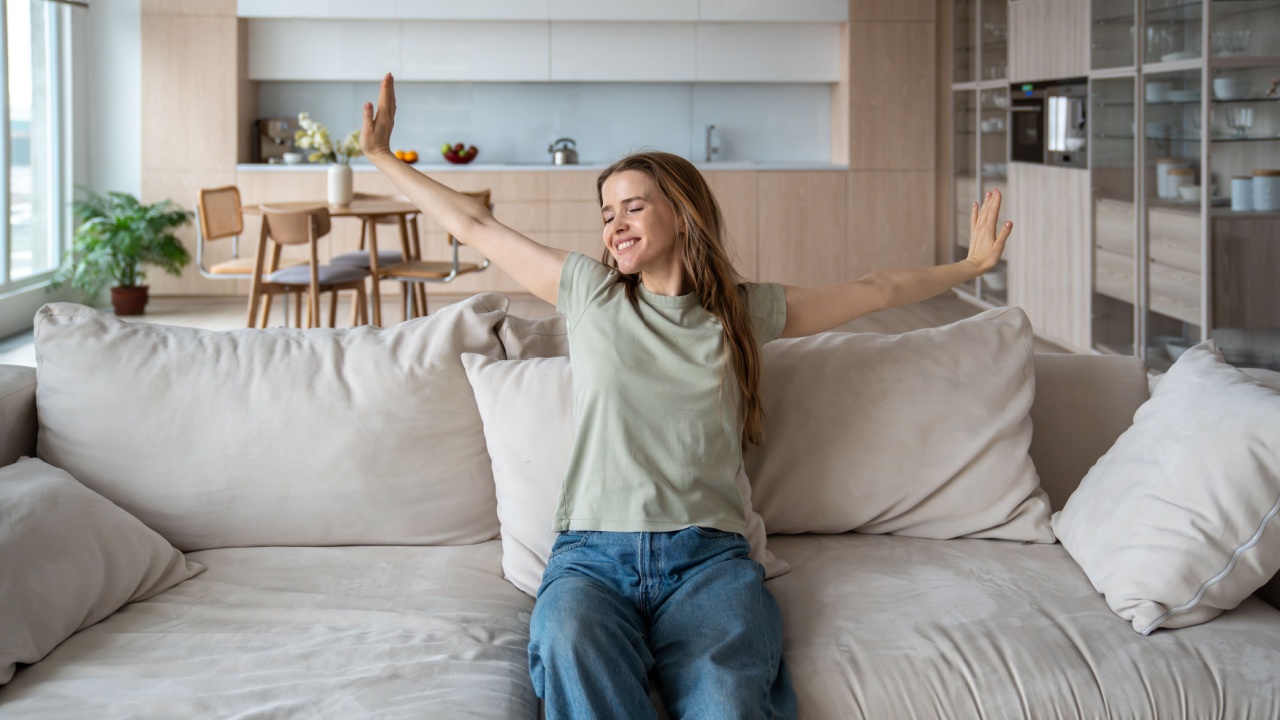 Relax, rest and wellbeing. Young happy dreamy woman kicked back relaxing on sofa at home, relaxed female resting after work in apartment. Happy girl enjoy lazy weekend or vacation in cozy living room