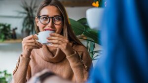 Young caucasian couple coworkers partners drinking coffee in cozy loft coffee shop