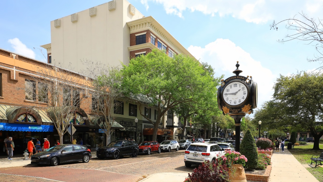 WINTER PARK, FLORIDA, USA: Rotary clock, flower pots, retail stores with brick roads in downtown Winter Park. Famous for it's upscale shopping and world class museums, as seen on March 9, 2024.