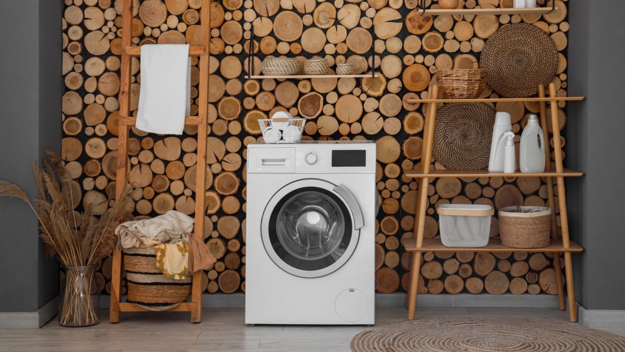 Interior of laundry room with washing machine, basket and shelf unit