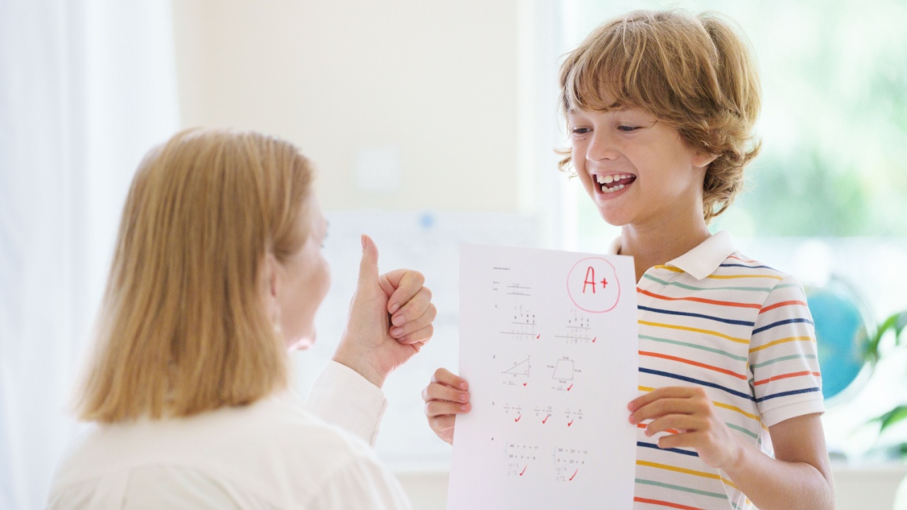 Child holding school test with excellent A grade. Student happy after exam. Little boy with A note paper in his hands. Tuition and homework help for best grades in school.