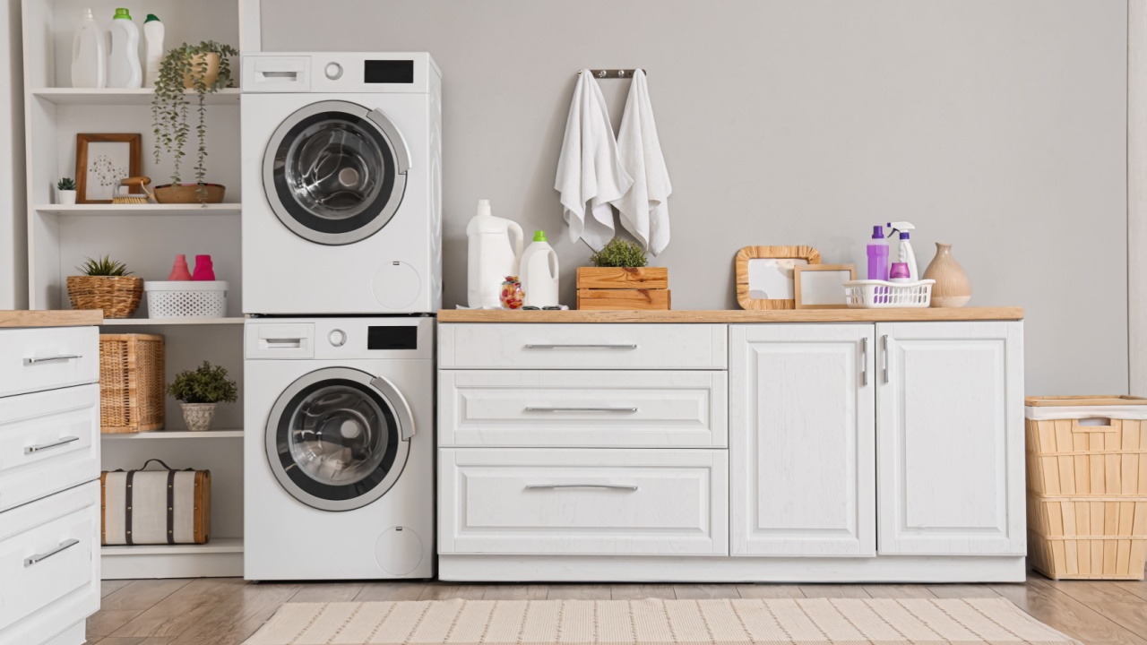 Interior of modern laundry room with washing machines and cleaning supplies