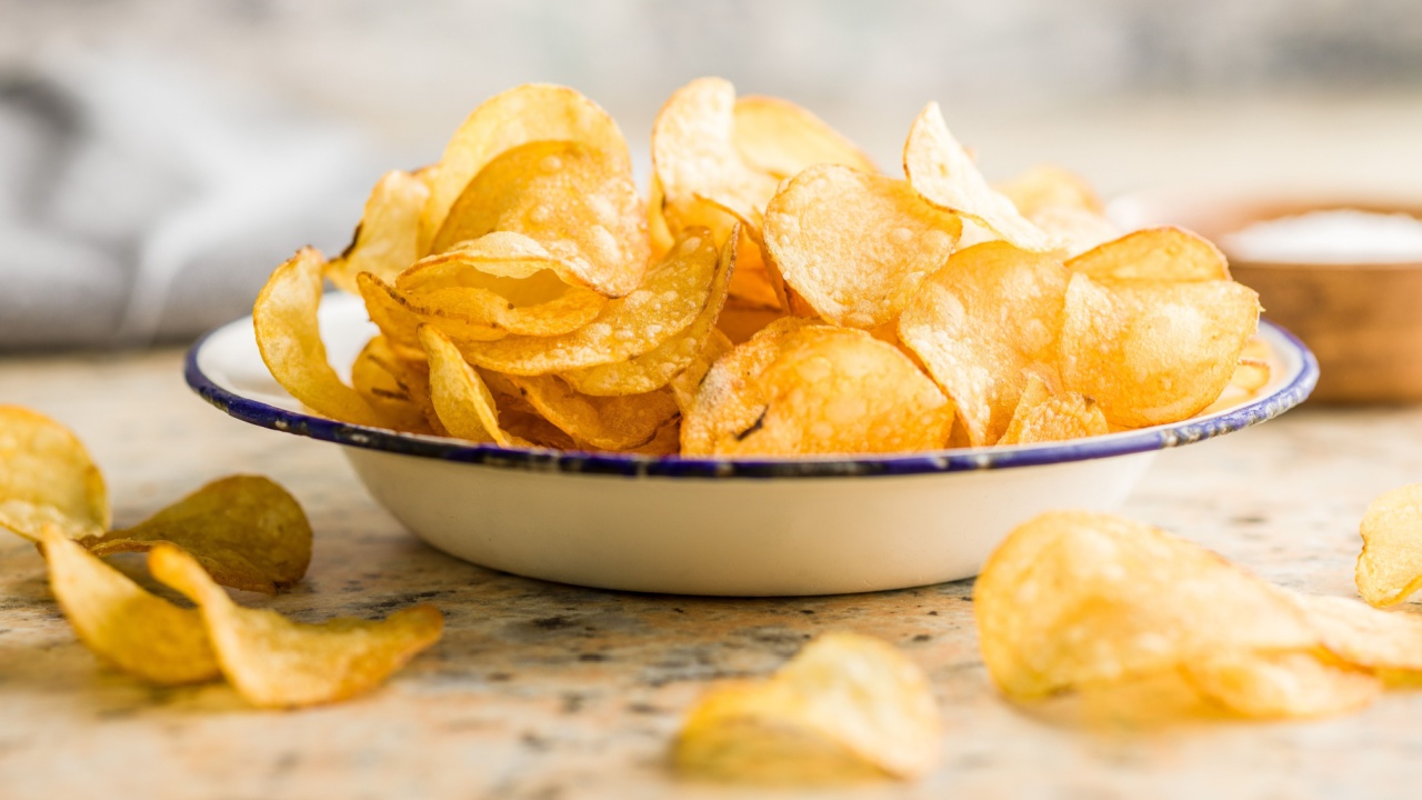 Crispy Potato Chips in bowl on a kitchen table.