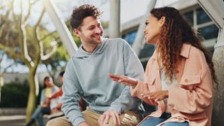 Relax, college or students on break talking or speaking of scholarship, education or future plan on campus. Learning, school or happy friends speaking in university bonding in fun social conversation