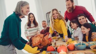 Photo of big family celebrating thanksgiving day meeting together preparing main dish stuffed turkey indoors