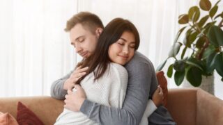 Reconciliation Concept. Multicultural Couple Hugging Supporting Each Other Or Reconciling After Quarrel At Home